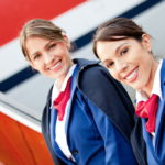 Friendly Air Hostesses Smiling And Welcoming Into The Airplane